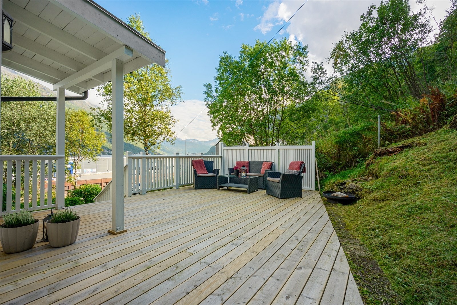 Her er det god plass til både sittegruppe, grill og utemøbler - her kan du sitte i le for naboer og nærhet til naturen Galleribilde