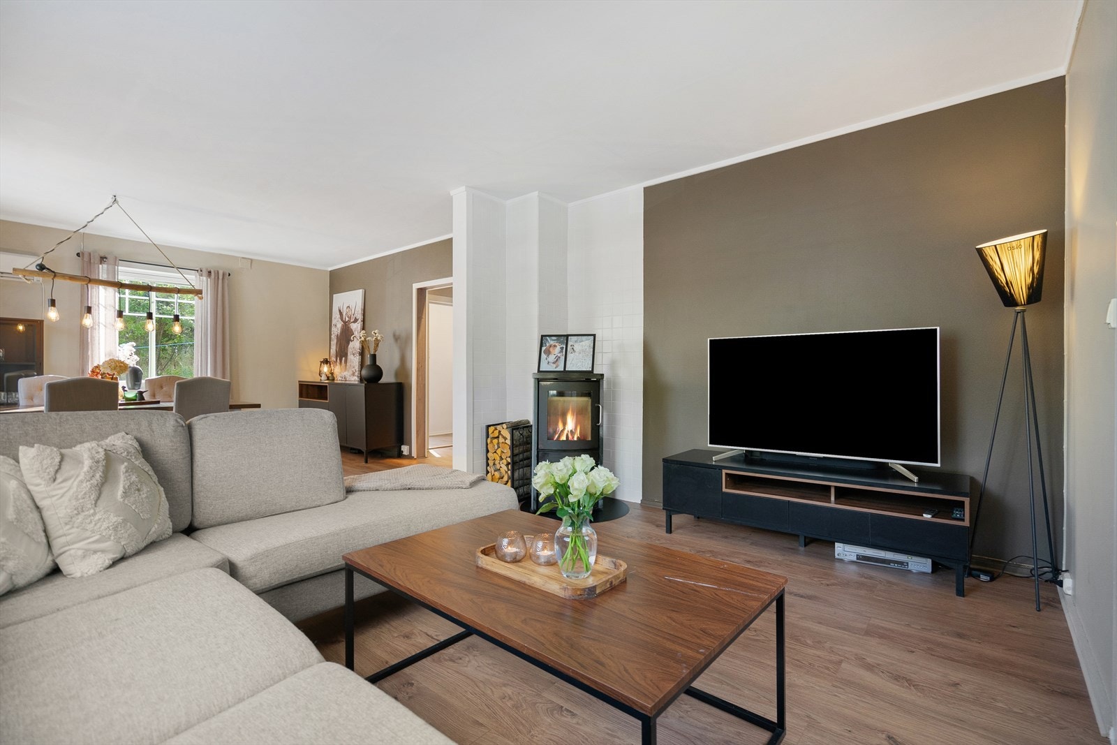 Lys og romslig stue i behagelige farger utstyrt med vedovn som skaper en lun atmosfære Galleribilde