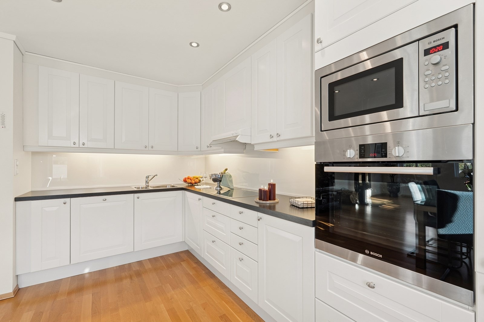 Innholdsrik kjøkkeninnredning med skap helt til taket. God benkeplass til matlaging! Galleribilde