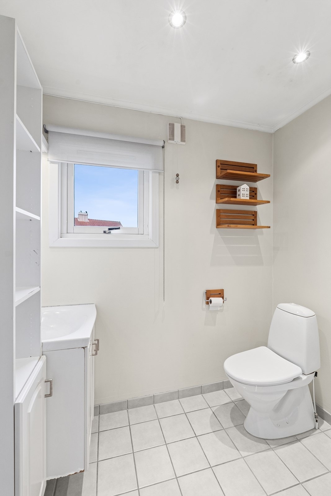 Rommet er enkelt utstyrt med servantinnredning, toalett og dusjnisje, i tillegg til at det er varmekabler i gulvet. Galleribilde