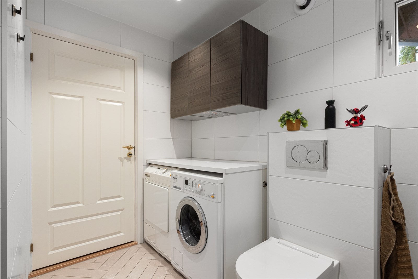 Det flotte baderommet har egen vaskeromsdel med opplegg for vaskemaskin og tørketrommel, samt praktisk skap for oppbevaring. Galleribilde