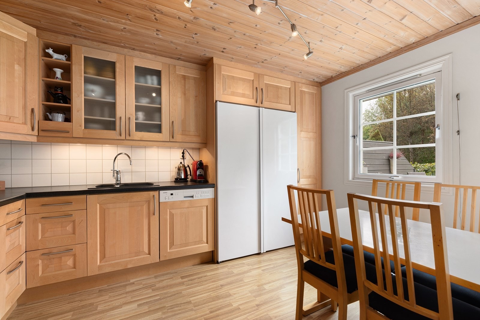 Stort og lyst kjøkken med fin spiseplass. Kjøkkenet har integrerte hvitevarer. Galleribilde