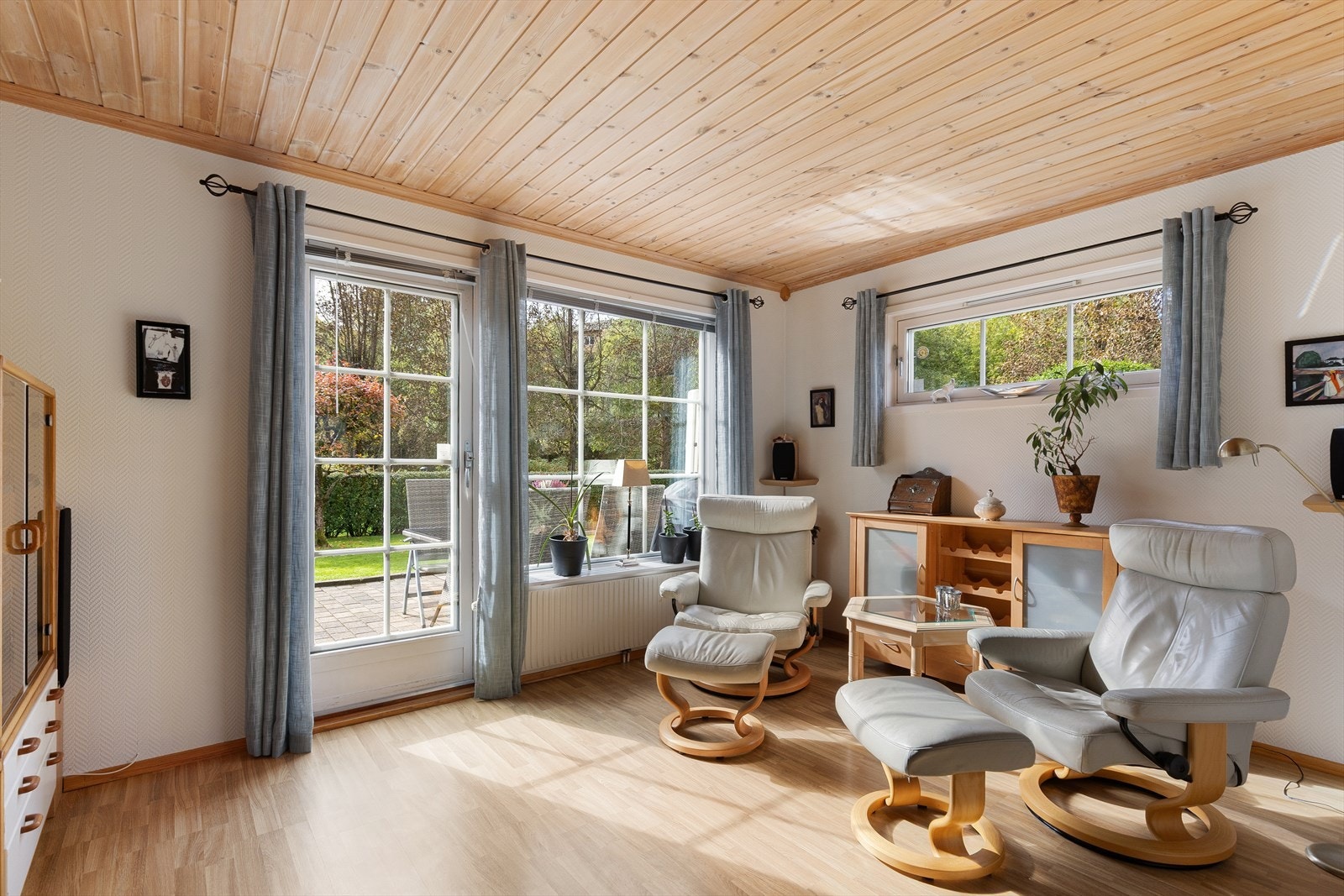 Store vindusflater gir utsyn mot hageområde. Galleribilde