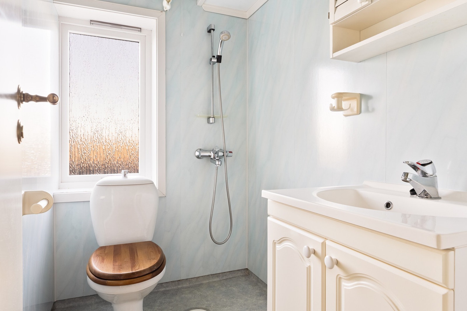 Badet har vinylbelegg på gulvet, våtromsplater på veggene og tak-ess plater i taket. Innredet med toalett, skap med overliggende servant og dusjhjørne. Galleribilde