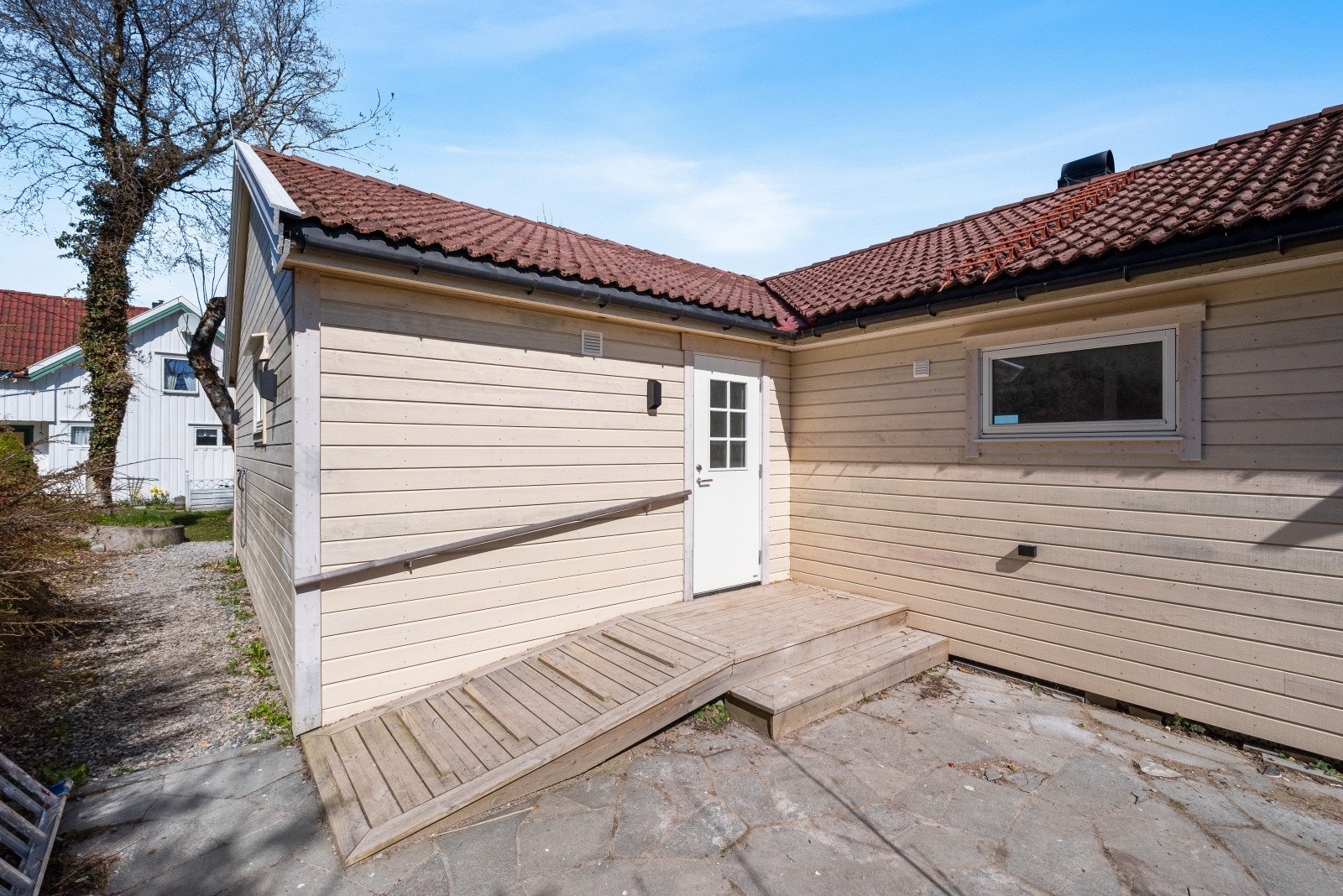 Det er gruset gangsti rundt boligen, pen utebelysning på vegg og nye rør fra utvendig kran inn til bolig Galleribilde