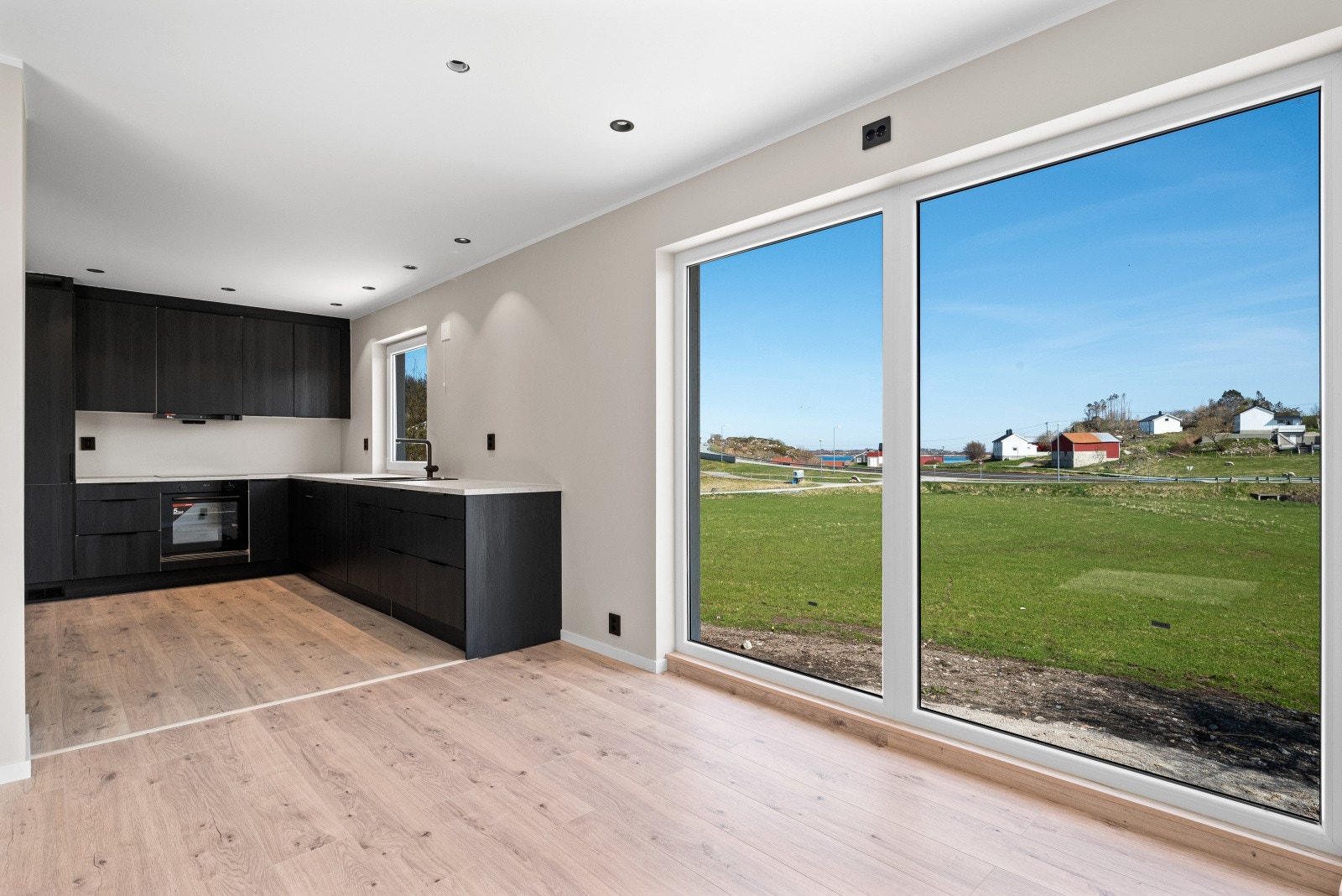 På den ene veggen har stuen vindusflater helt ned til gulvet, slik at den vidstrakte utsikten blir en del av rommet Galleribilde