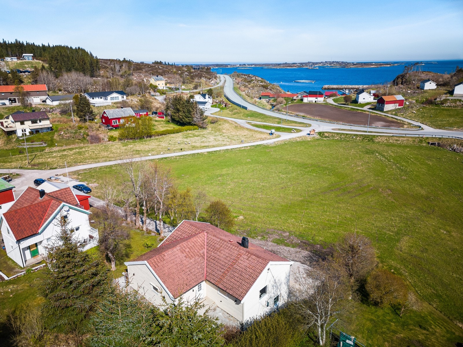 Eiendommen har en skrånende tomt på ca. 609 kvm, med stor gruset gårdsplass i forkant av boligen Galleribilde