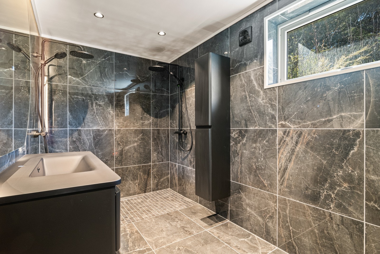 Badet har ellers veggmontert toalett, downlights i himlingen og mekanisk avtrekk Galleribilde