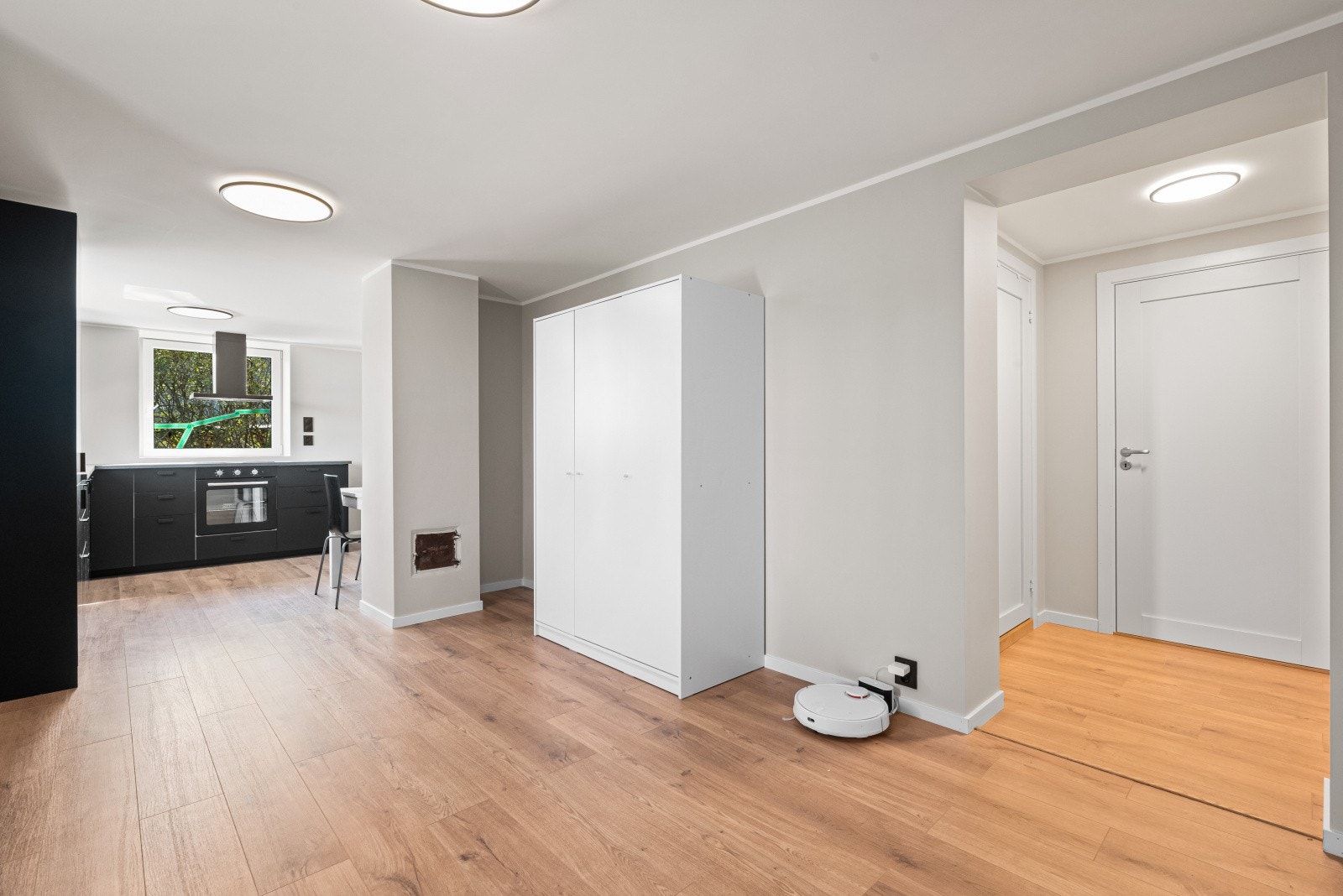 Ved inngang til leiligheten er det et hvitt garderobeskap slik at yttertøy og sko kan ryddes unna Galleribilde