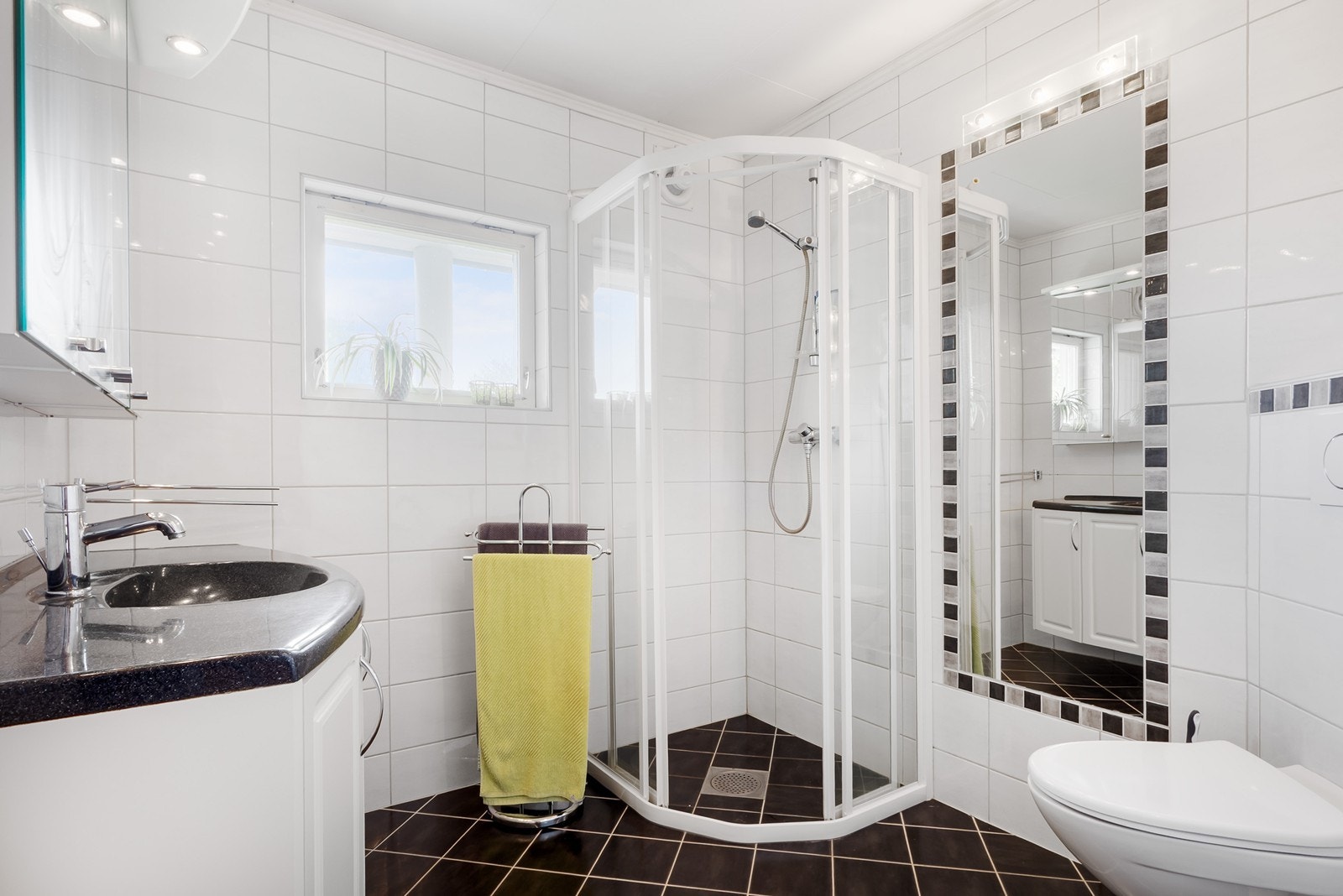 Badet i 1. etasje fra 2007 har flislagte overflater og gulvvarme, innredet med dusjhjørne med kabinettdører, servantskap og toalett. Galleribilde