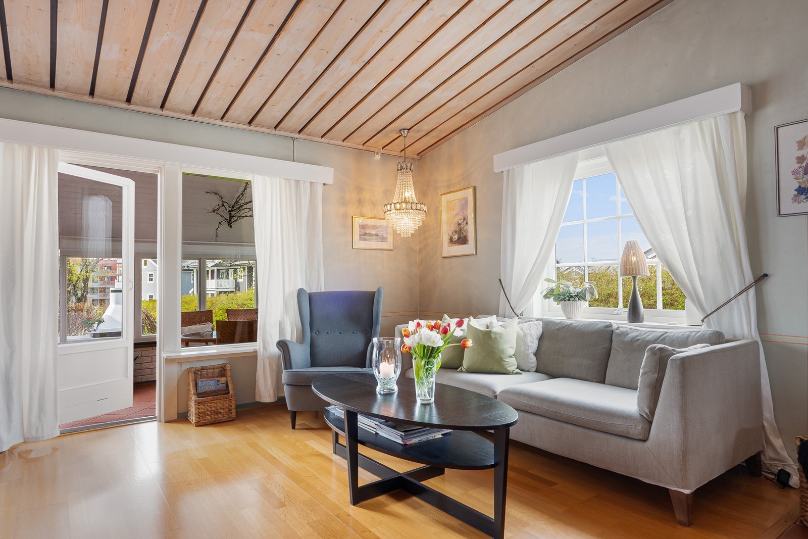 Fra peisestuen fører glassdør ut til overbygd og delvis innglasset veranda. Galleribilde