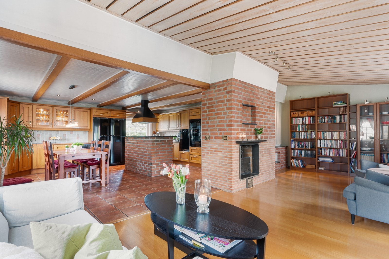 Den åpne løsningen gir fin romflyt, med blikkfang i form av dekorativ rød murstein på kjøkkenøy og murt peis. Galleribilde