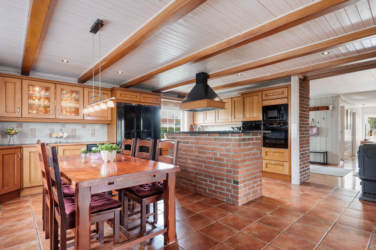 En elegant kjøkkenøy gir et skille mellom matlagning og spisestue. Det flislagte gulvet har varmekabler. Galleribilde