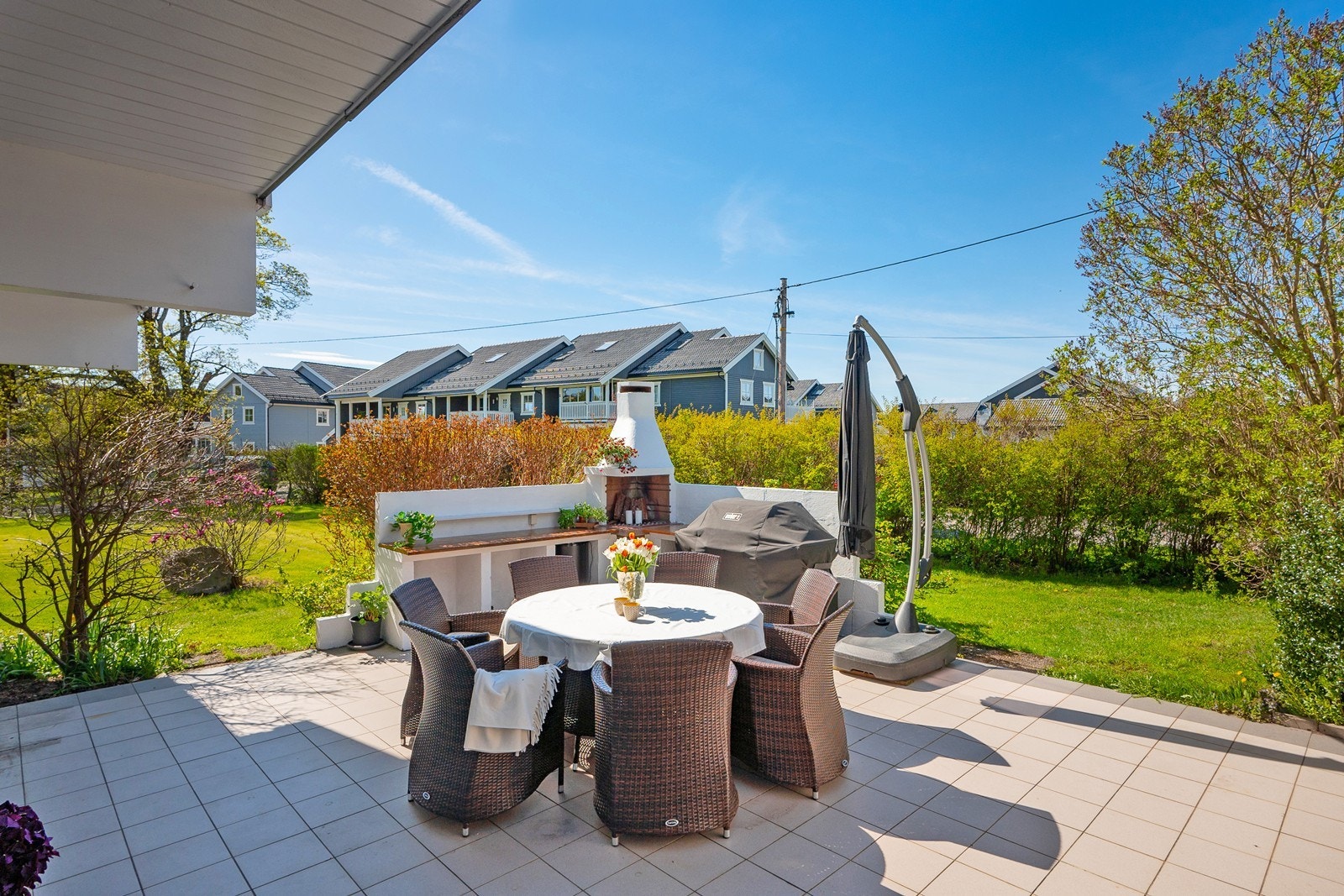 Terrassen på 40 kvm har flislagt dekke og direkte overgang til grønn hageplen. Galleribilde