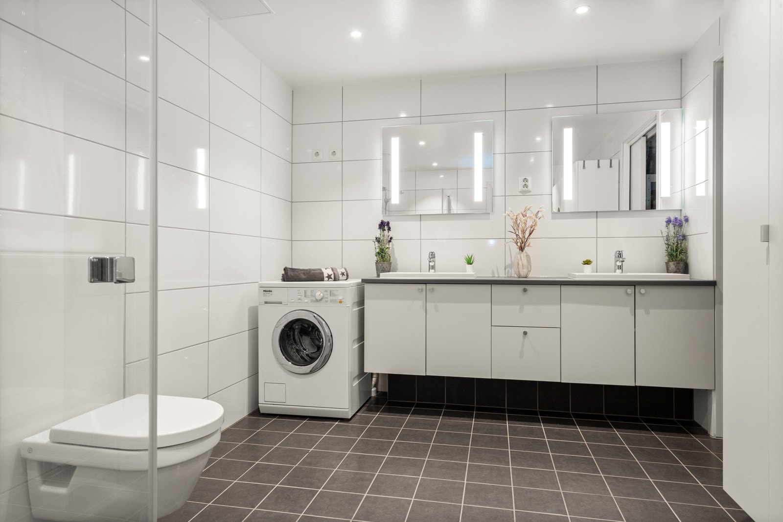 Det delikate baderommet er oppført i moderne stil med flislagte overflater og vannbåren gulvvarme. Galleribilde