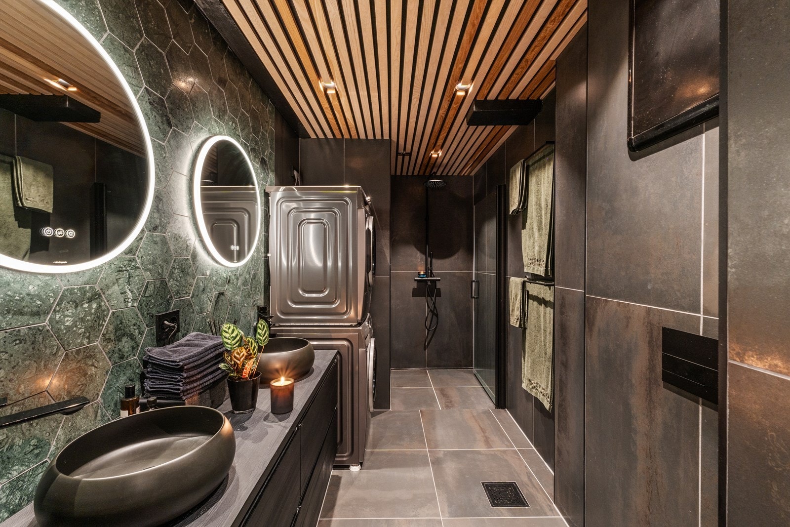 Eksklusivt bad fra 2021 med mørk fargepalett og innslag av varme spiler for et rolig uttrykk. Baderomsinnredning fra Vikingbad og armatur fra Tapwell. Galleribilde