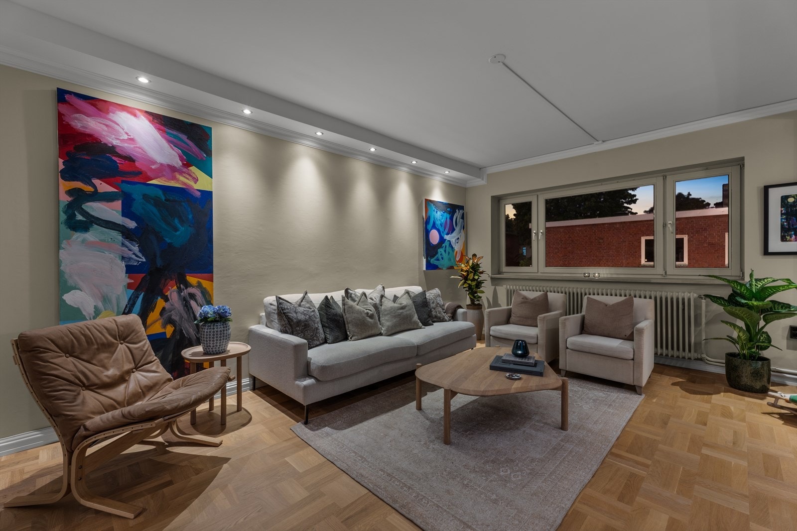 Den romslige stuen god plass til stor sofagruppe og flere stoler. Leiligheten varmes opp med fjernvarme. Galleribilde