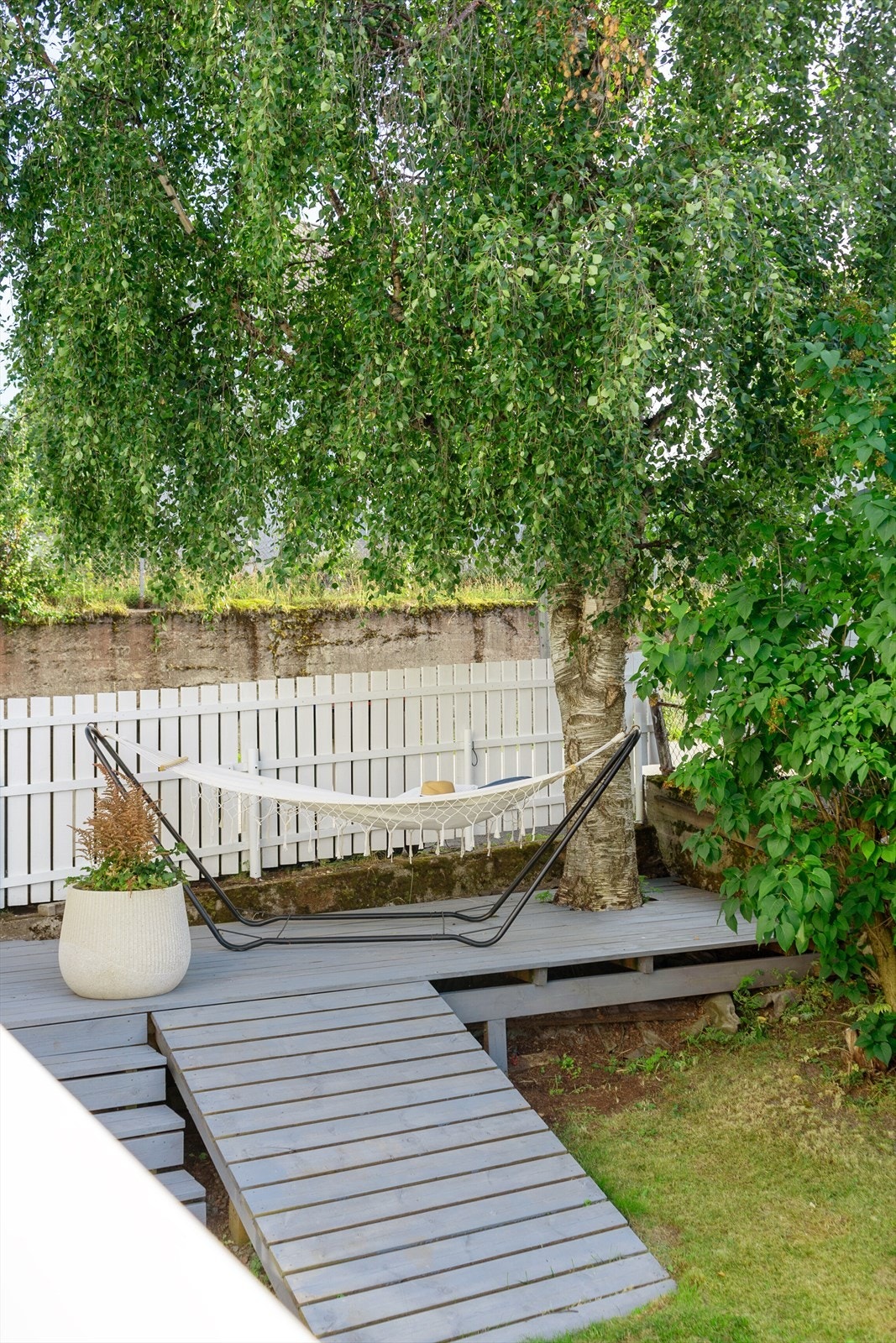 Et lite fristed i hagen - hengekøyen under trekronene byr på deilig skygge og ro, perfekt for en bok eller en liten hvil Galleribilde