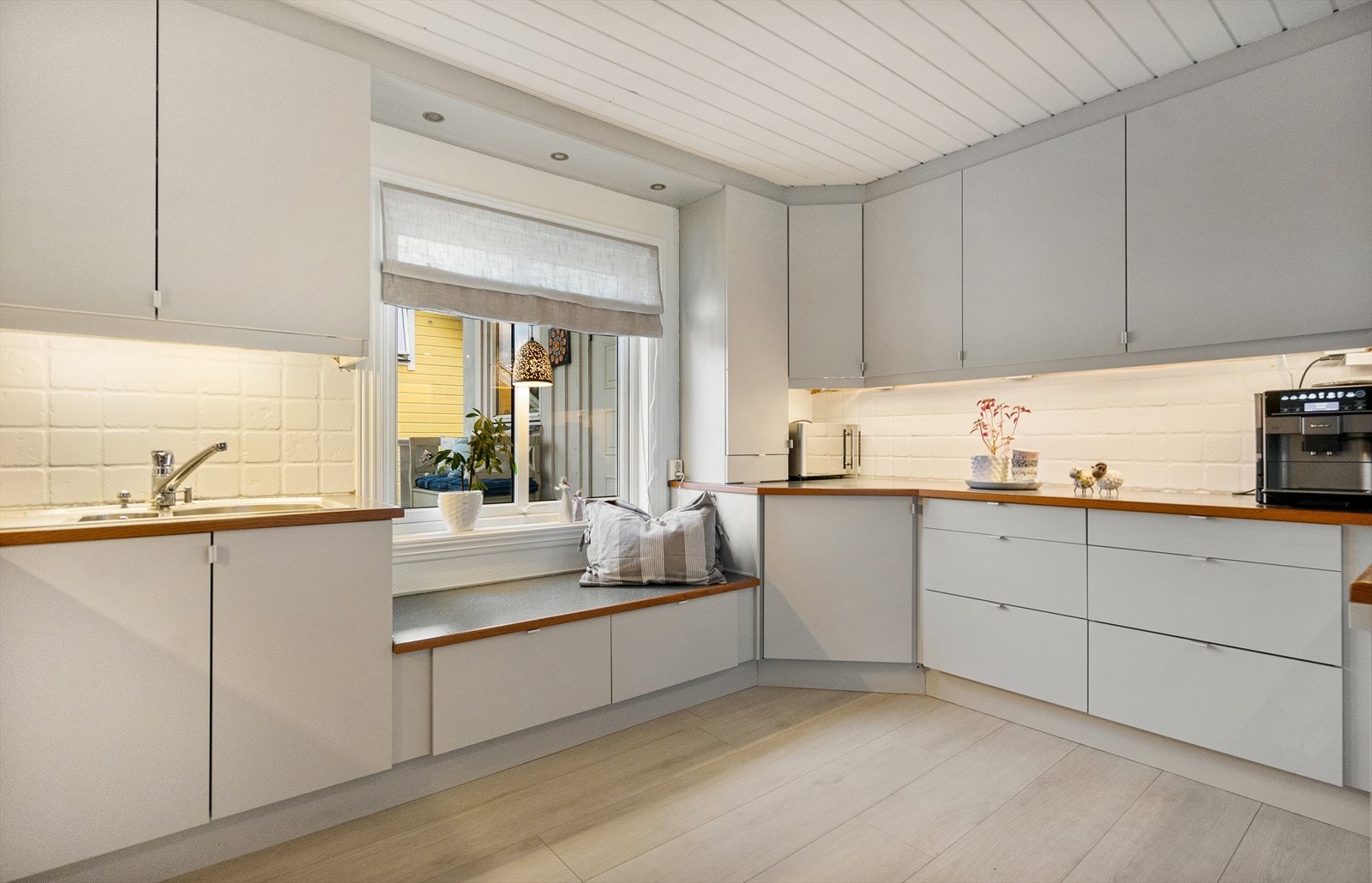 Den koselige sitteplassen ved vinduet gjør kjøkkenet til mer enn bare et sted å lage mat - her kan du nyte kaffekoppen i fred Galleribilde