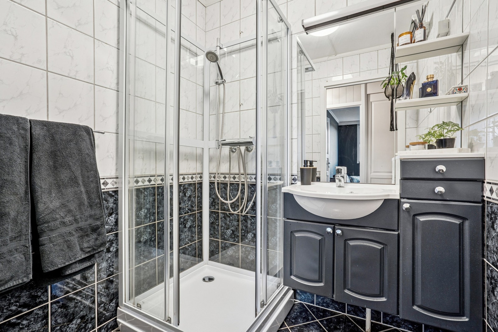 Badet er flislagt på både gulv og vegger, og er innredet med servant, dusjkabinett og god plass til oppbevaring. Galleribilde