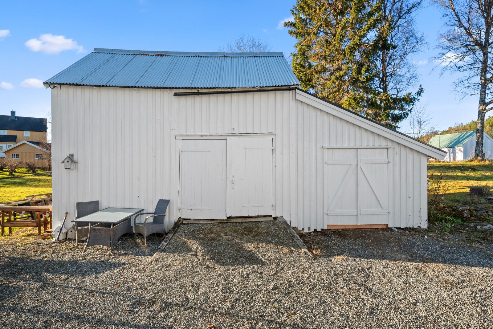 På eiendommen står det et eldre garasjebygg med slagdører. Galleribilde