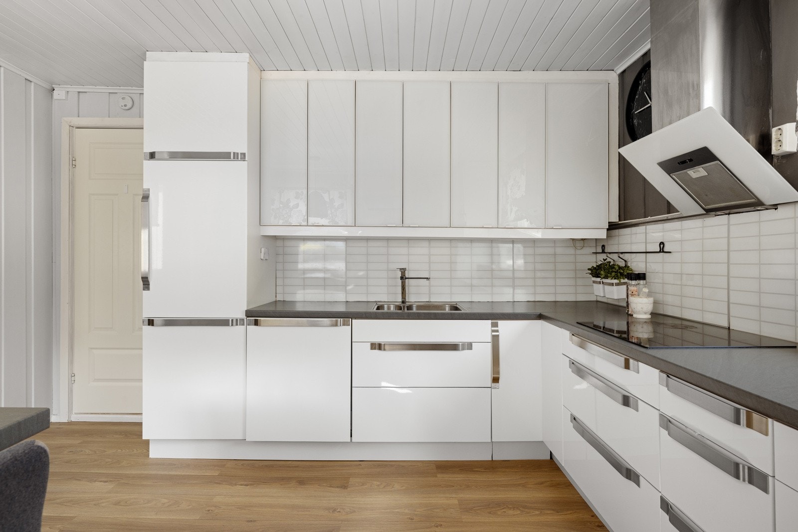 Kjøkkenet har stilren, hvit innredning med glatte fronter fra IKEA og laminat benkeplate Galleribilde