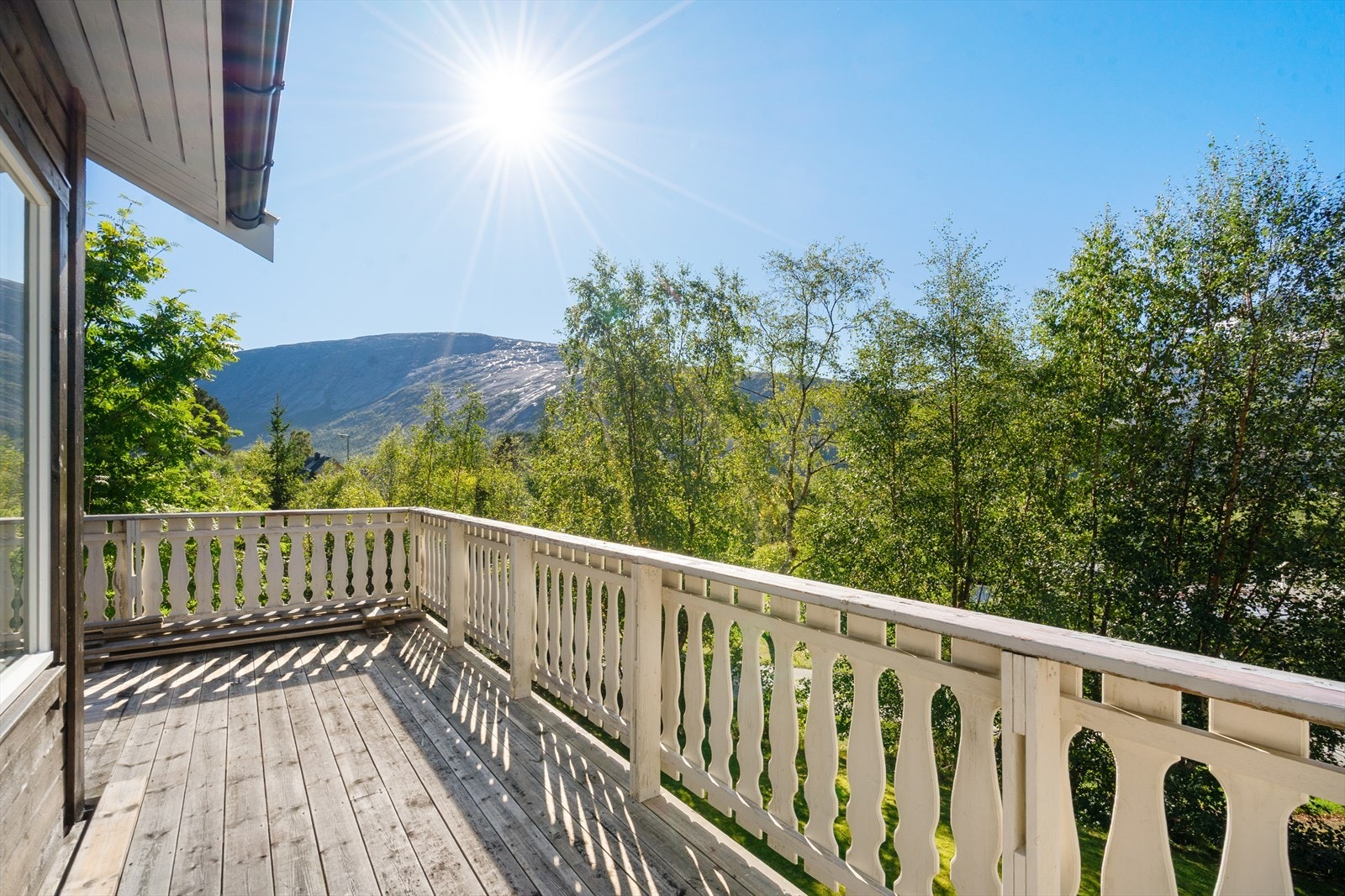 Her får du nyte solen fra tidlig til sent, omgitt av grønne trær og med majestetiske fjell som bakteppe Galleribilde