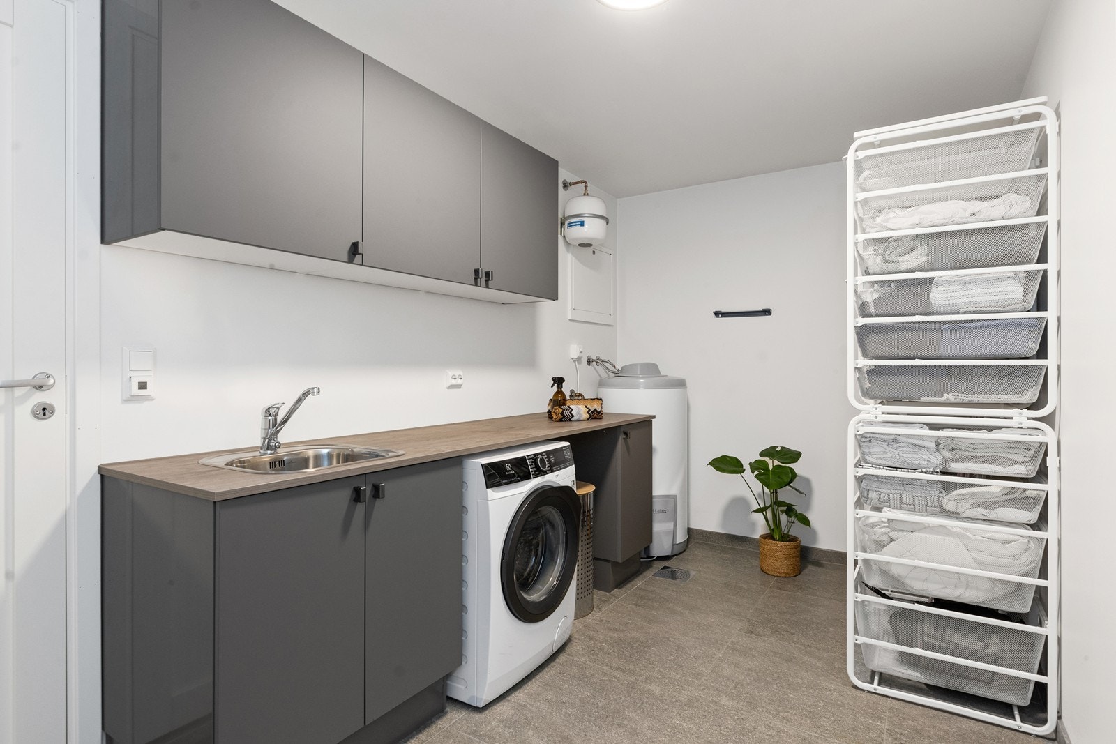 Vaskerommet i underetasjen har innredning med over-/underskap, opplegg for vaskemaskin, varmtvannsbereder samt varme i gulv Galleribilde