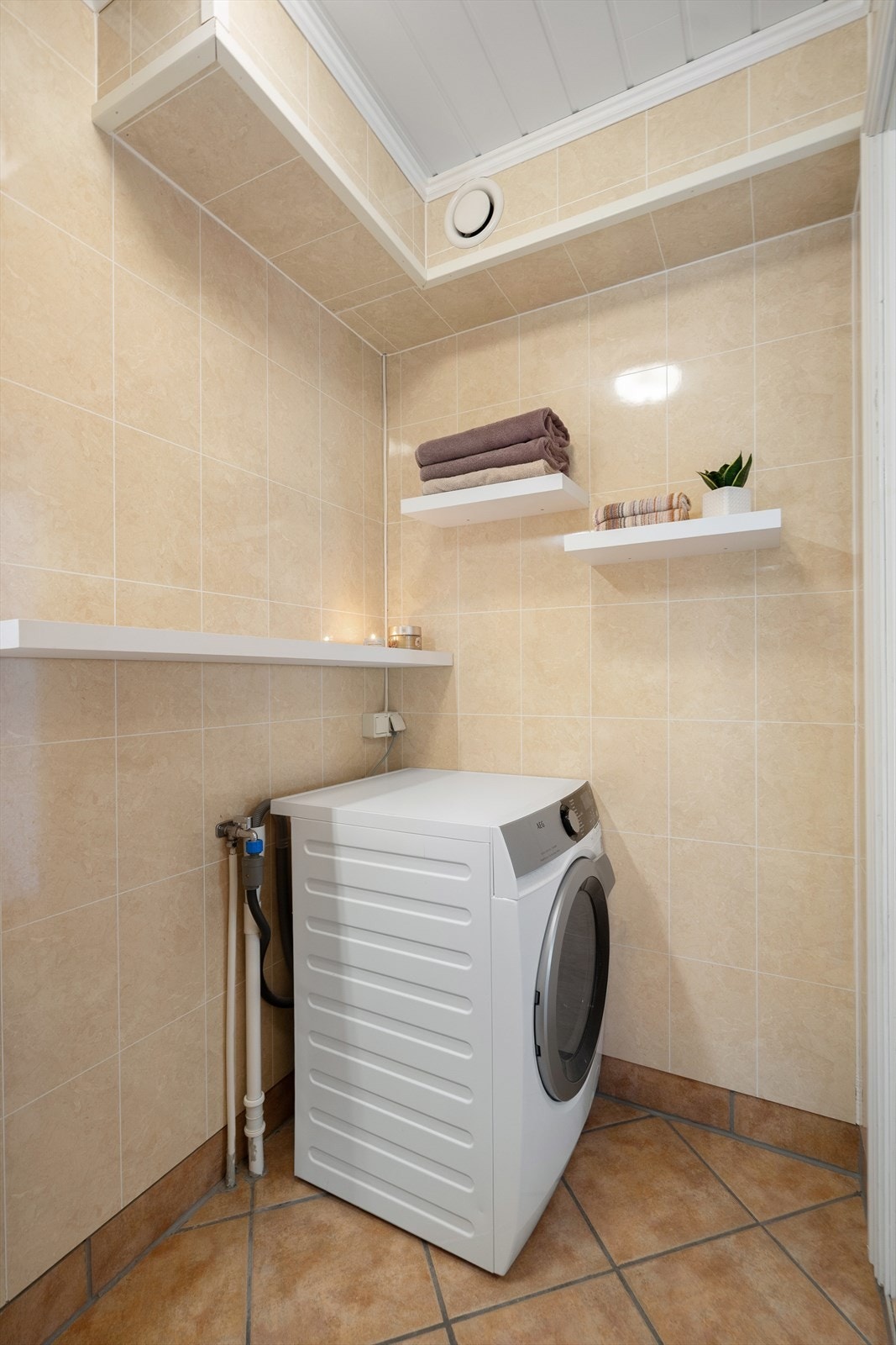 Badet har opplegg for vaskemaskin, samt smarte hyller som gir god plass til håndklær og oppbevaring av toalettsaker Galleribilde