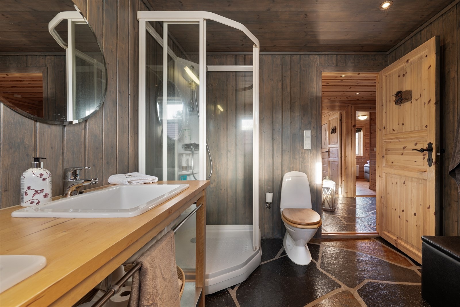 Bad med skifer på gulv og beiset panel på vegger. Galleribilde