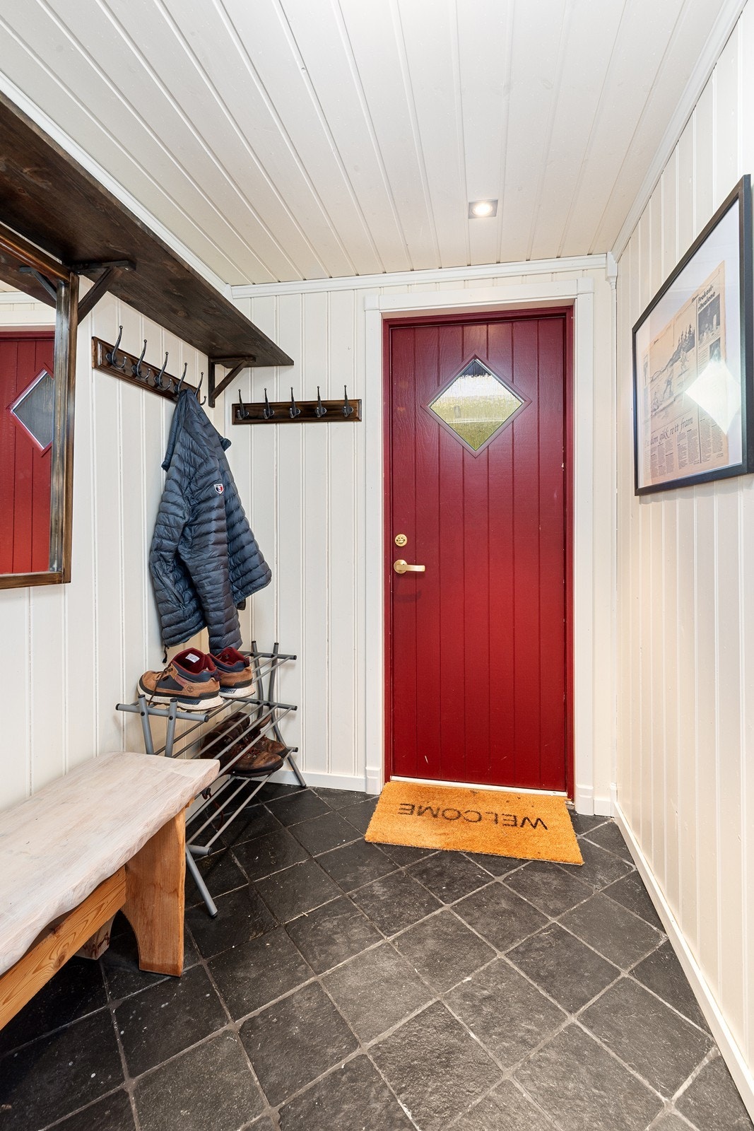 En flislagt entré med mulighet for oppheng av yttertøy ønsker deg velkommen inn! Galleribilde