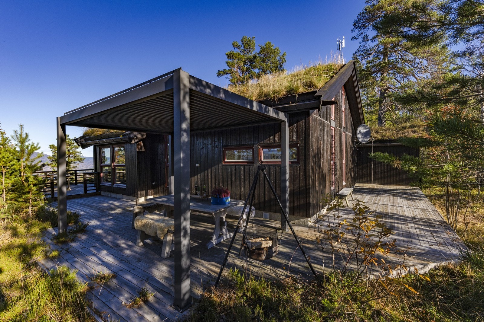 Hytta har terrasse som strekker seg rundt hele tre av hyttas fasadesider. Galleribilde