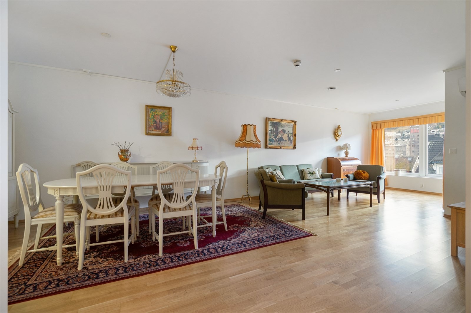 Stor og luftig stue med store vinduer som slipper inn rikelig med dagslys. Rommet gir god plass til både sofagruppe og spisestue, og har en lun og trivelig atmosfære Galleribilde