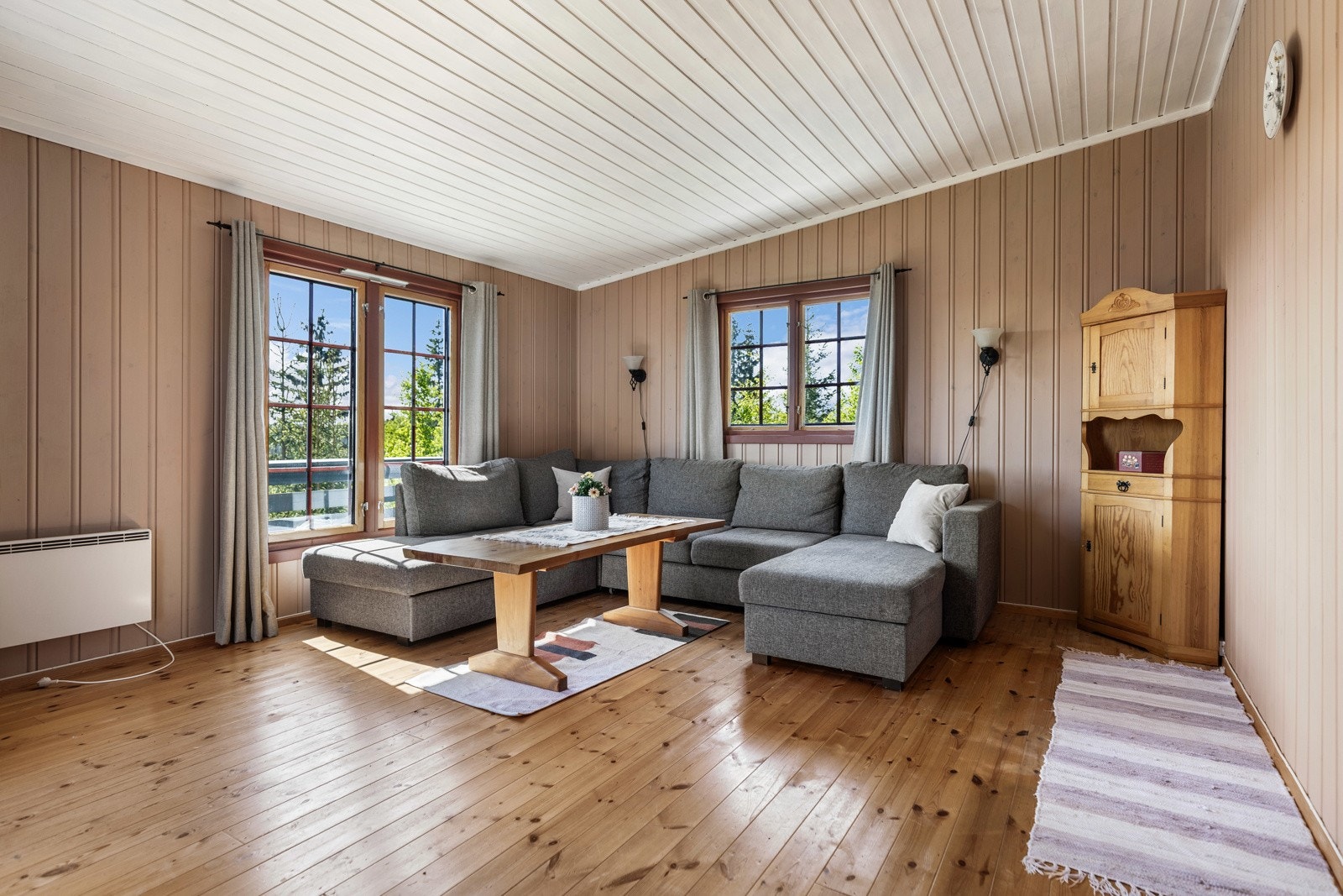 Stuen er delvis malt i en dus-jordtone og vinduer i tre retninger gir gode lysforhold og strålende utsikt over alt det grønne. Galleribilde