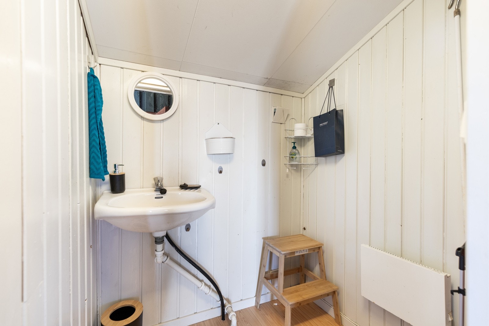 Boden vegg i vegg er innredet med panelovn og en enkel servant. Galleribilde