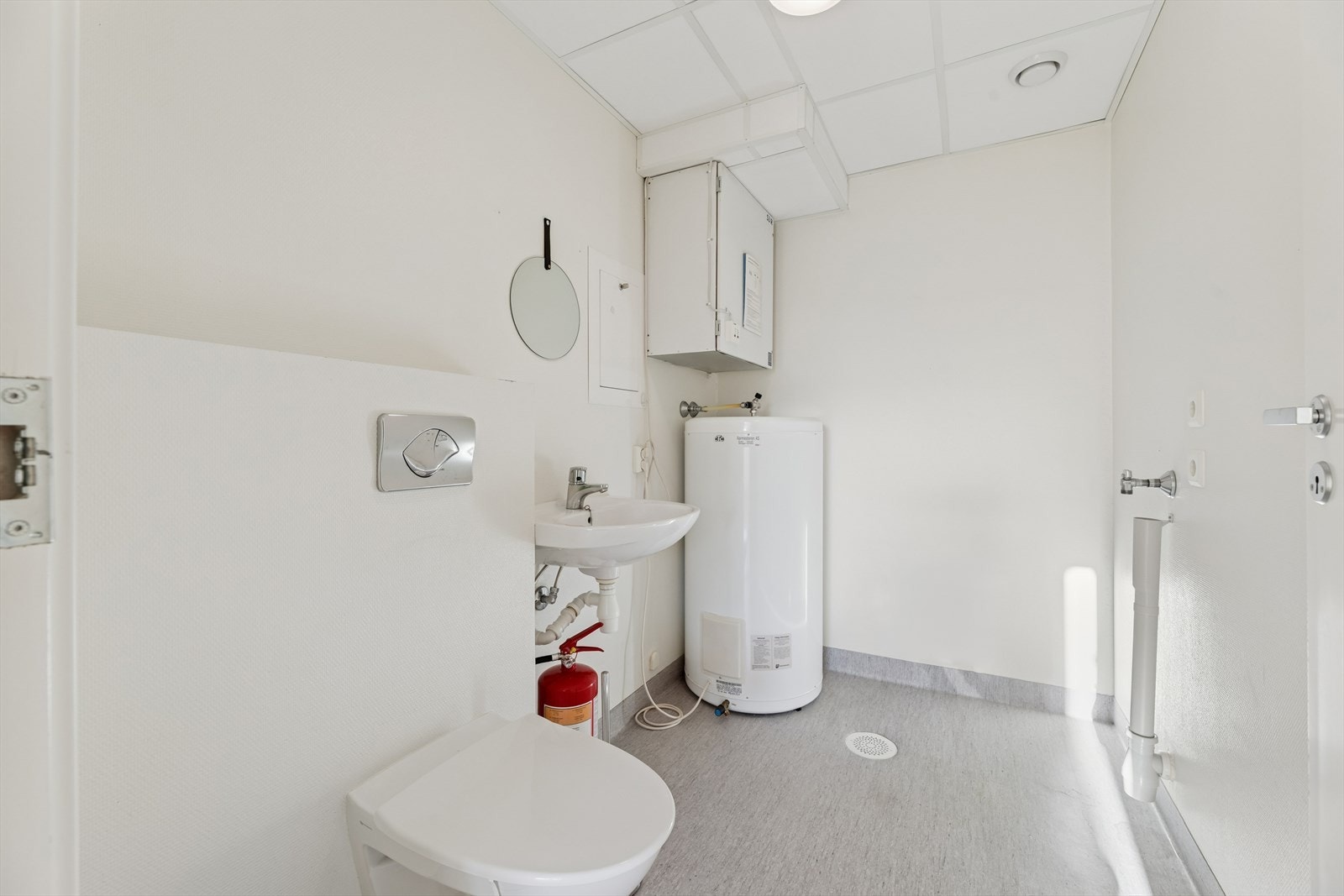 Like ved baderommet finner man et vaskerom som er innredet med belegg på gulv og malte flater. Rommet er ellers utstyrt med vegghengt toalett, servant og varmtvannsbereder. I tillegg har man opplegg for vaskemaskin. Galleribilde