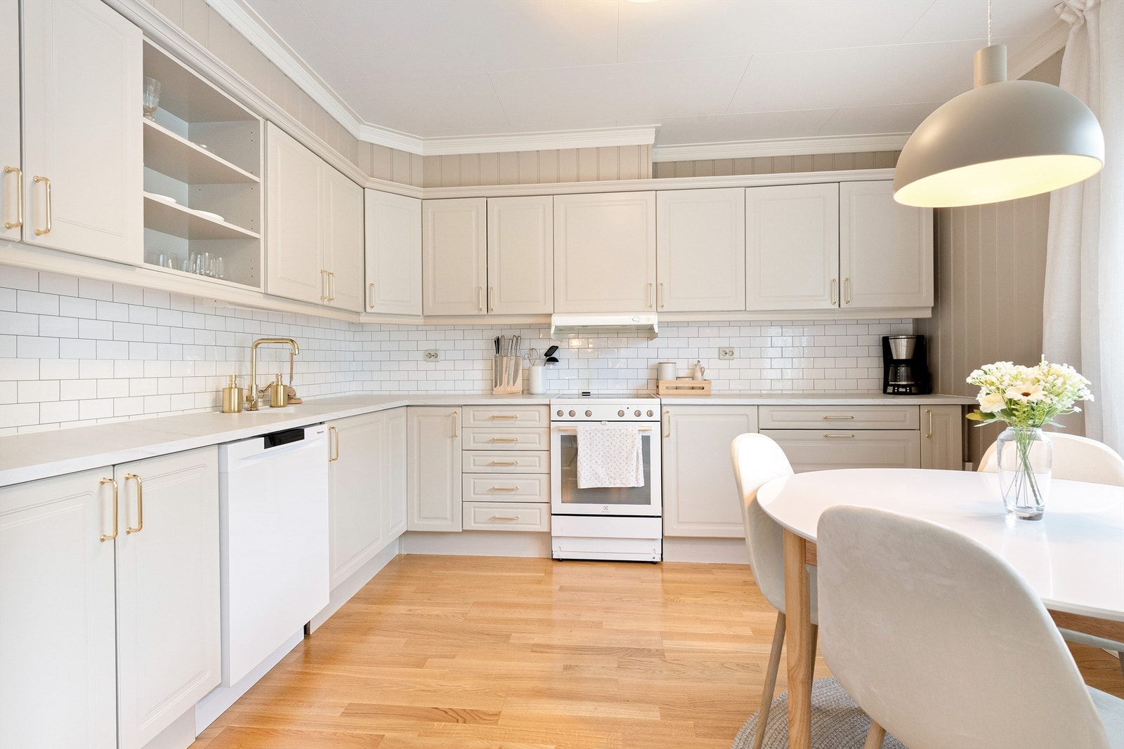 Kjøkkenet er levert av Sigdal og har innredning med profilerte fronter, laminatbenkeplate og flisfolie mellom benk og overskap Galleribilde