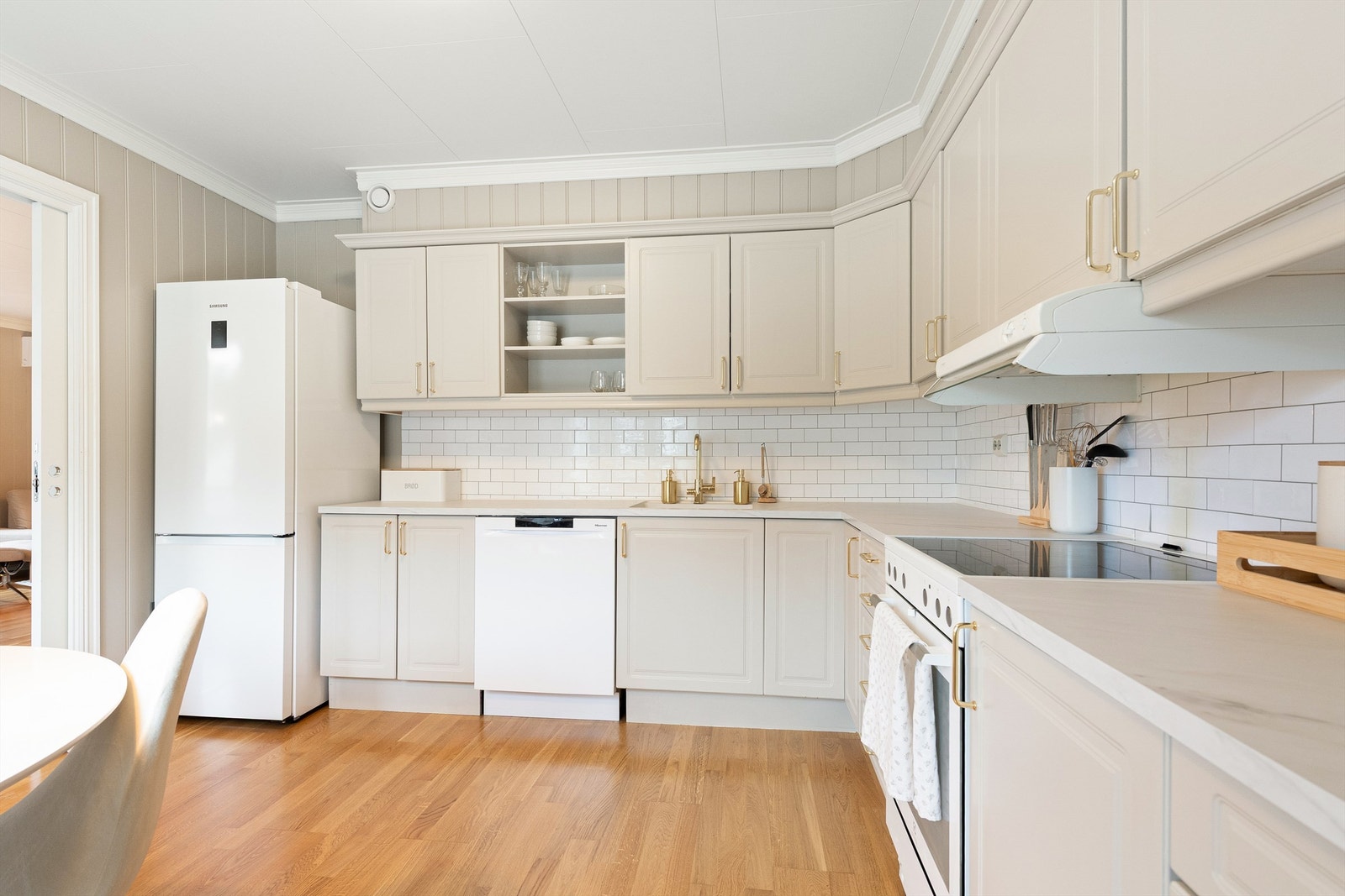 Kjøkkenet er tidløst og delikat, utformet i en funksjonell L-form med gode arbeidsflater og rikelig skapplass. Galleribilde