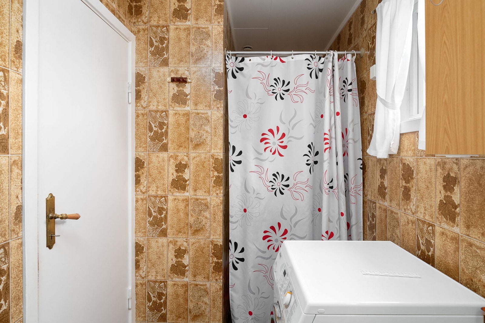 Badet har innredning med servantbeslag, dusjnisje, toalett og opplegg for vaskemaskin. Stråleovn på vegg. Galleribilde