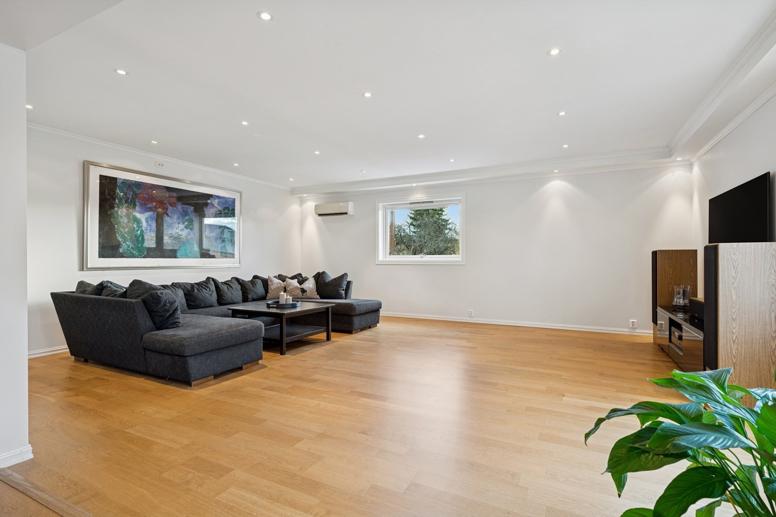 Stuen fremstår som lys og innbydende. Flotte detaljer med downlights i tak. Det er etablert varmepumpe på vegg. Galleribilde