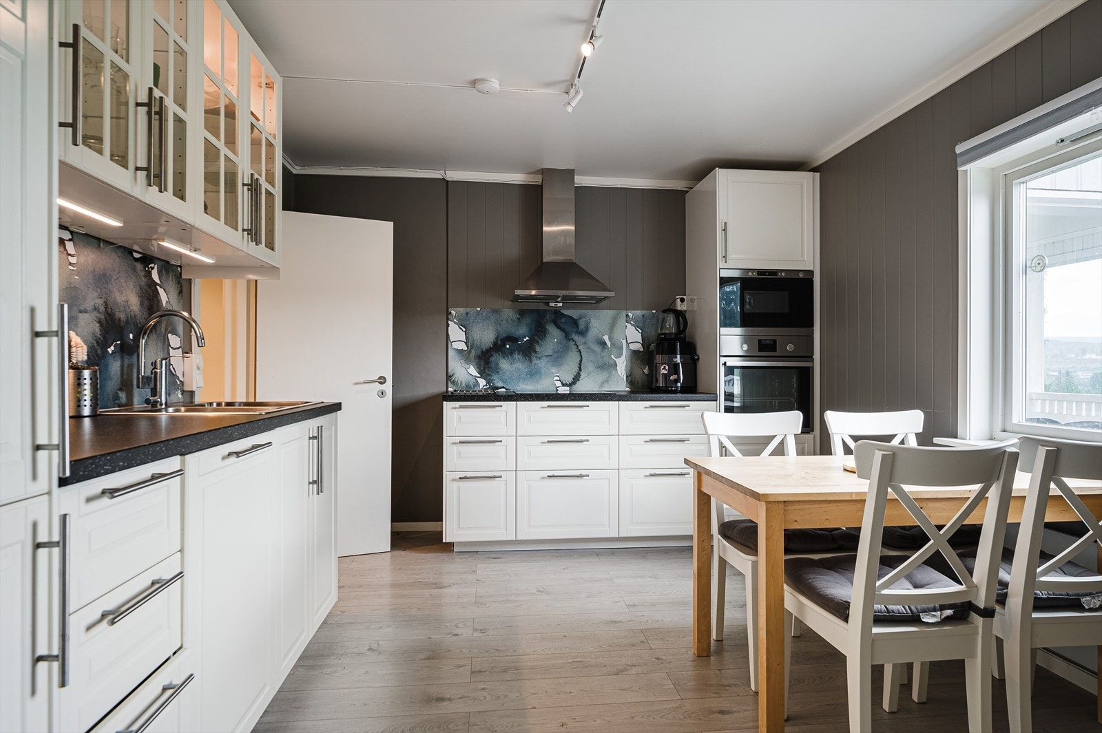 Fra leilighetens entre er adkomst til etasjens romslig kjøkken med en nyere og klassisk innredning. Her er det integrerte hvitevarer, samt noen overskap med glassdører. Innredningen har fine arbeidssoner Galleribilde