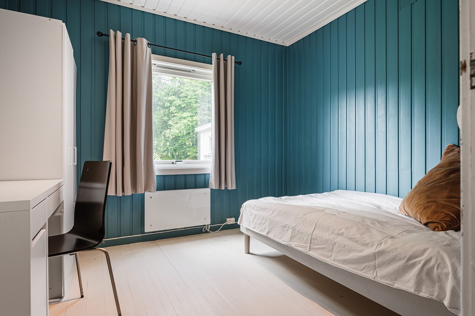 Ett soverom malt i en dyp og lun blåfarge. Galleribilde