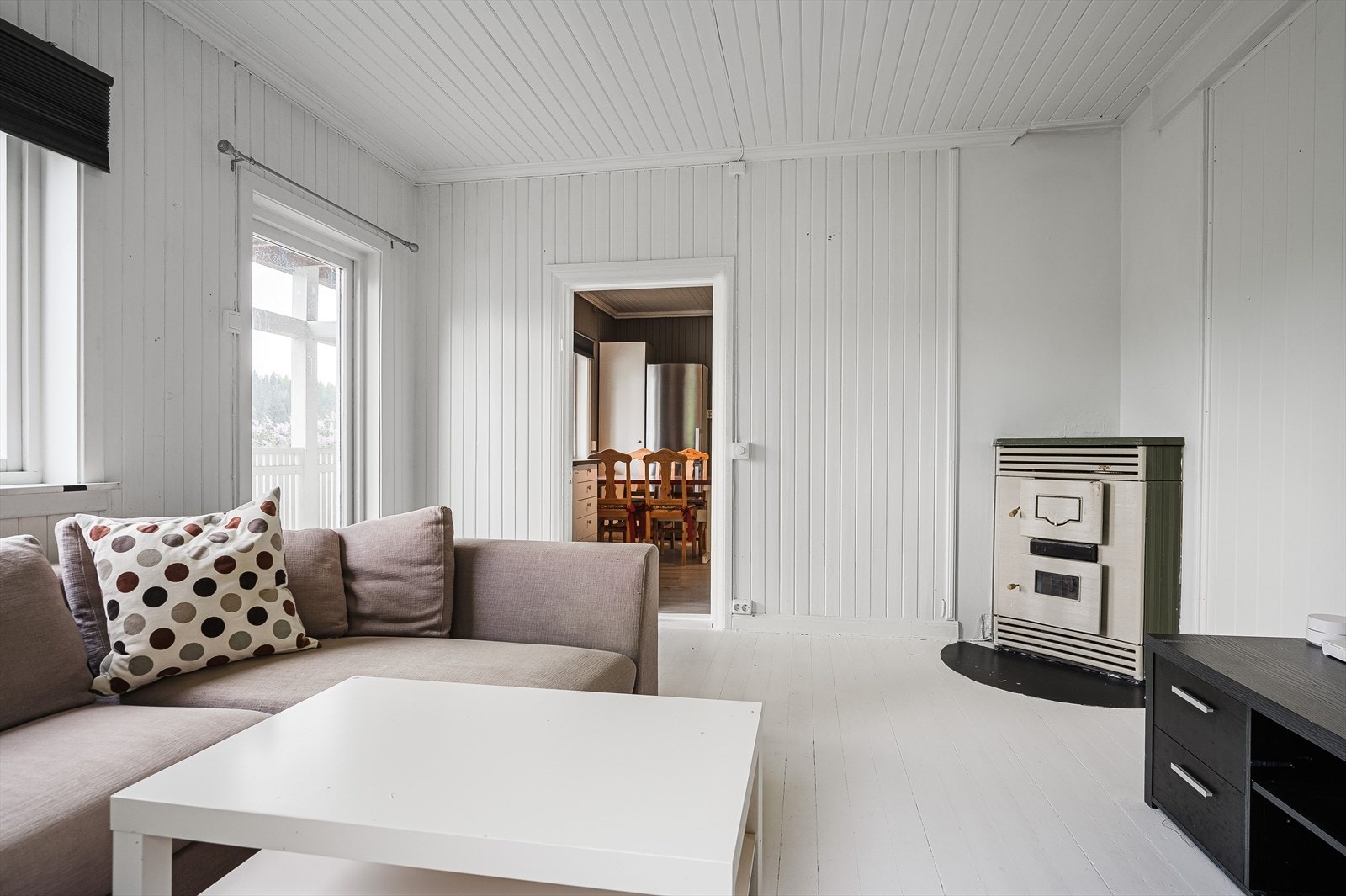 Stuen har adkomst fra kjøkkenet og her er det lysmalte gulv og vegger. Merk også den gode takhøyden i rommet. Galleribilde