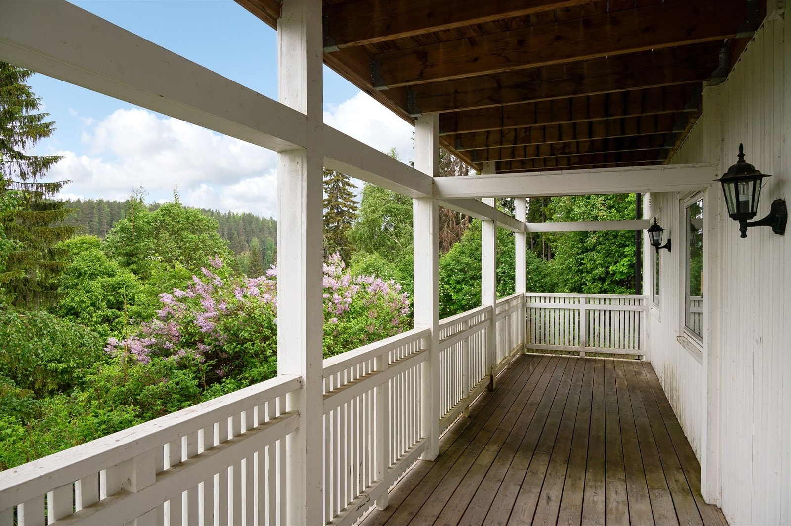 Balkongen har plass for flere sittegrupper og utegrill. Et godt sted å være selv om det skulle komme noen dråper med sommerregn. På ende er det trapp ned til hage og terreng. Galleribilde