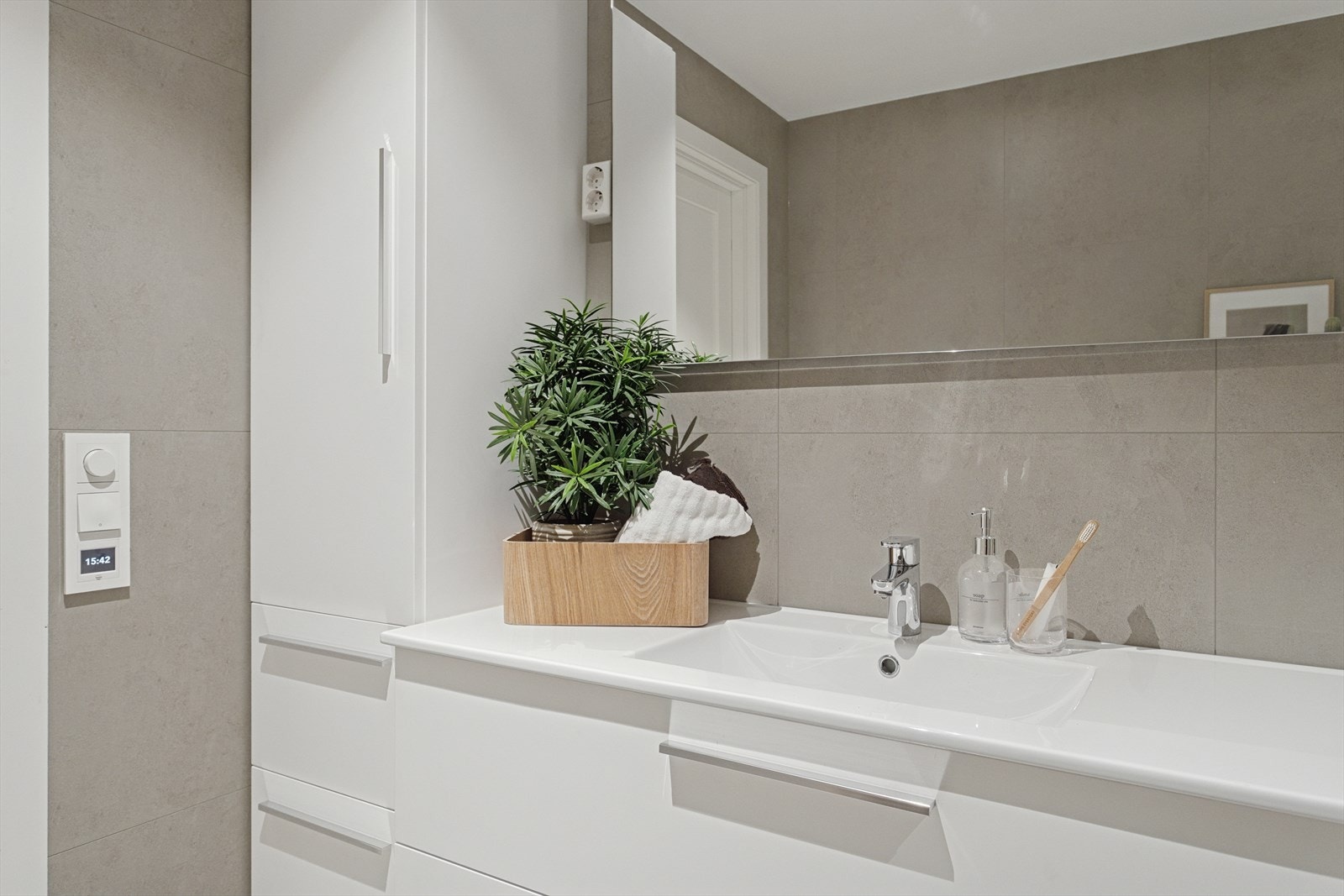 Baderommet har en lekker innredning med servant og speil over. Badet har i tillegg opplegg for vaskemaskin. Galleribilde