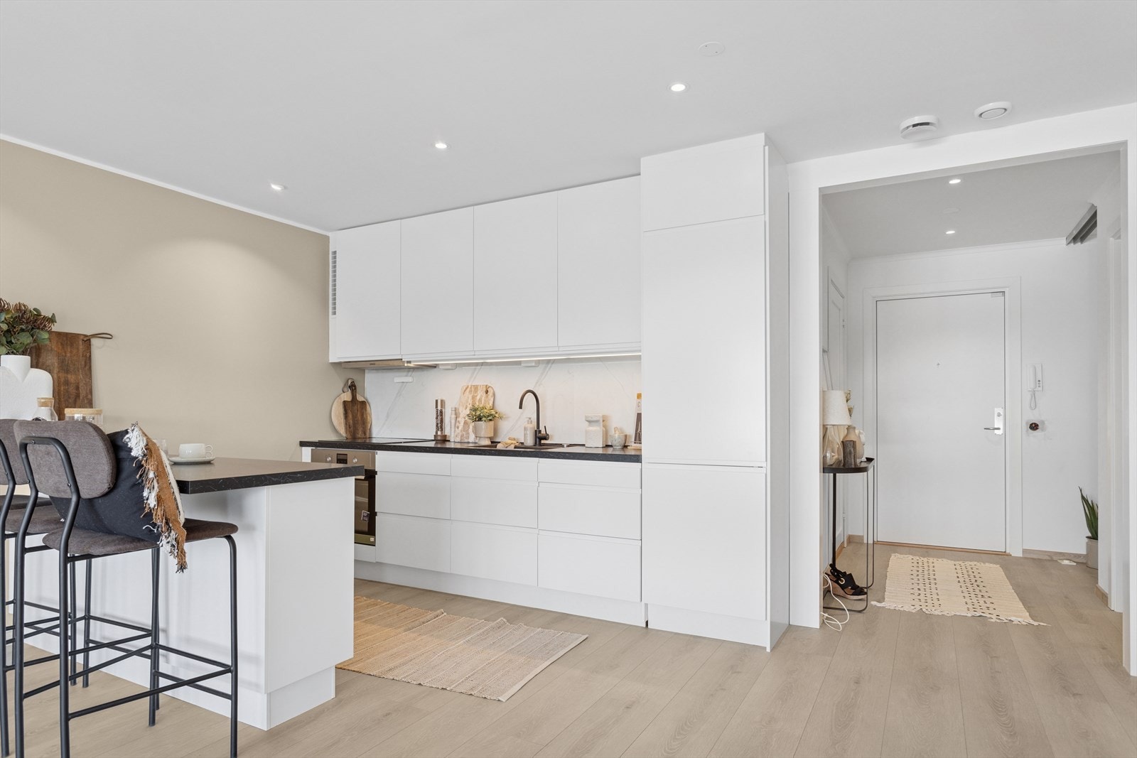 Kjøkkenet har en flott- og tidløs innredning som består av over- og underskap med folierte fronter og skrog. Laminat benkeplate med nedsenket oppvaskkum og platetopp. Galleribilde