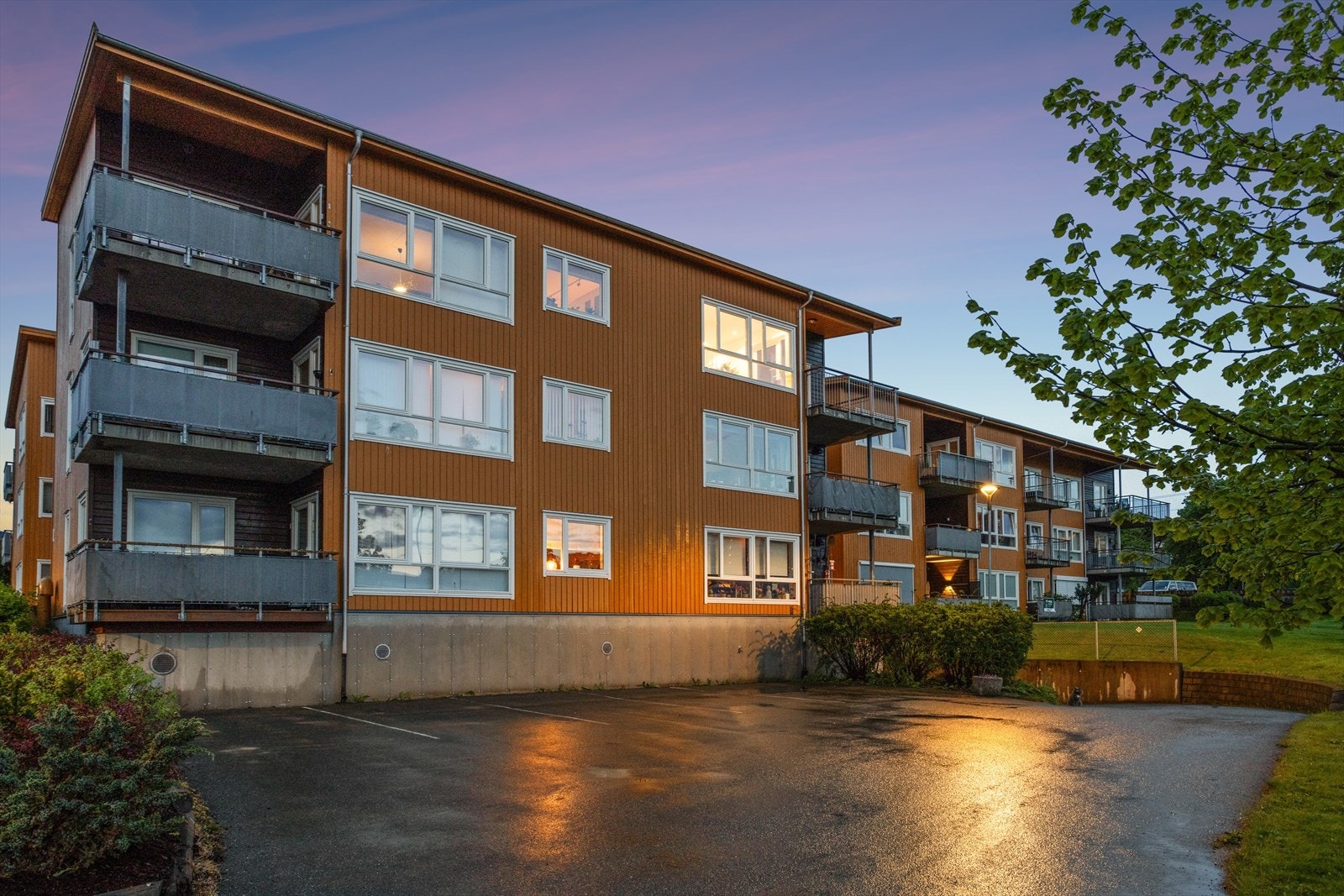 Fasade, gjesteparkeringsplass og nedkjørsel til til P-kjeller Anders Søyseths veg 12. Fast P-plass i kjeller medfølger boligen. Galleribilde