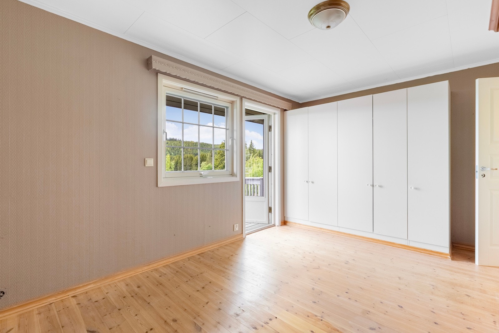 Hovedsoverommet fremstår som meget innbydende med malte vegger, heltre furugulv og garderobeskap. Galleribilde