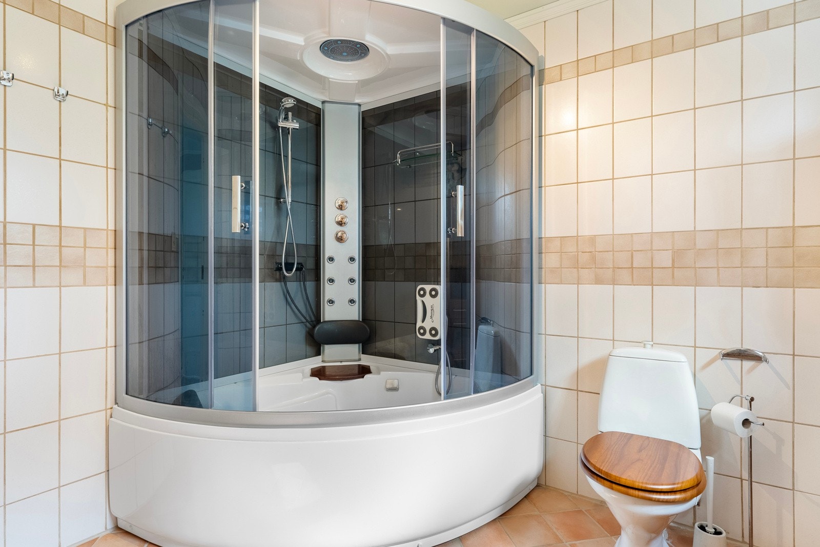 Badet dusjkabinett og gulvstående toalett. Galleribilde