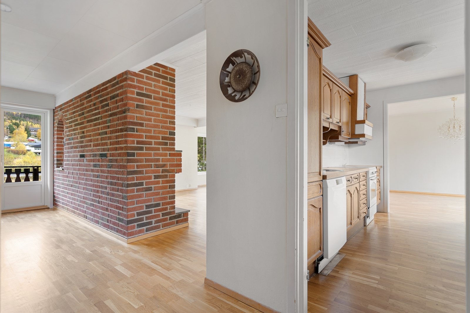 Fra gangen åpner hjemmet seg mot kjøkken og stue - med den flotte mursteinsveggen som et rustikt blikkfang og skille mellom sonene Galleribilde